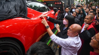 Hakim ketua Tipikor Efendi (kanan) memeriksa barang bukti berupa mobil Ferrari untuk terdakwa kasus dugaan suap terhadap putusan lepas perkara korupsi pemberian fasilitas ekspor minyak sawit mentah (CPO) Ariyanto Bakri (kiri) dan Marcella Santoso (tengah) di Pengadilan Tipikor, Jakarta, Rabu (14/1/2026). [ANTARA FOTO/Muhammad Adimaja/foc]