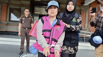 Petugas menggiring buronan terpidana kasus korupsi pemberian kredit fiktif Mila Indriani Notowibowo (tengah) di Kantor Kejaksaan Tinggi Bali, Denpasar, Bali, Rabu (14/1/2026). [ANTARA FOTO/Fikri Yusuf/foc]