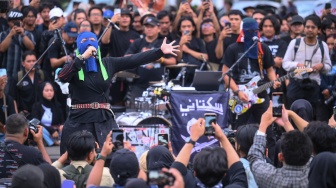 Personel Band Sukatani tampil saat aksi Kamisan ke-893 di depan Istana Merdeka, Jakarta, Kamis (15/1/2026). [ANTARA FOTO/Hafidz Mubarak A/rwa]