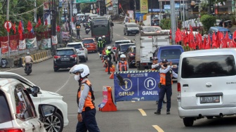Petugas Sat Lantas Polres Bogor bersama petugas Dishub Kabupaten Bogor mengarahkan kendaraan wisatawan saat penyekatan kendaraan nomor polisi ganjil genap di jalur wisata Puncak, Gadog, Kabupaten Bogor, Jawa Barat, Jumat (16/1/2026). [ANTARA FOTO/Yulius Satria Wijaya/bar]