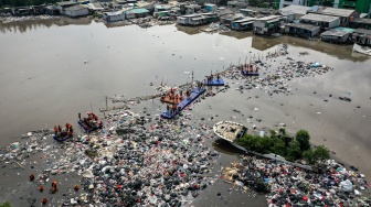 Foto udara petugas mengangkut sampah di kawasan Muara Baru, Jakarta, Jumat (16/1/2026). [ANTARA FOTO/Sulthony Hasanuddin/bar]