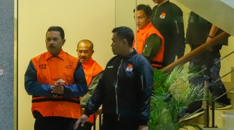 Wali Kota Madiun Maidi (tengah) dibawa ke mobil tahanan usai menjalani pemeriksaan di Gedung Merah Putih KPK, Jakarta, Selasa (20/1/2026). [Suara.com/Alfian Winanto]
