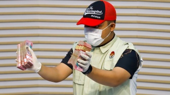 Petugas menunjukan barang bukti hasil Operasi Tangkap Tangan (OTT) terkait fee proyek dan dana CSR di wilayah Madiun saat Konferensi Pers di Gedung Merah Putih KPK, Jakarta, Selasa (20/1/2026). [Suara.com/Alfian Winanto]