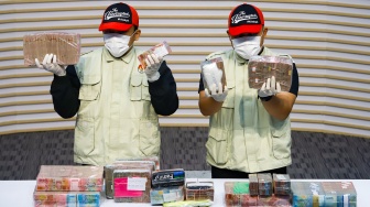 Petugas menunjukan barang bukti hasil Operasi Tangkap Tangan (OTT) terkait dugaan korupsi pengisian jabatan perangkat desa di Kabupaten Pati saat konferensi pers di Gedung Merah Putih KPK, Jakarta, Selasa (20/1/2026). [Suara.com/Alfian Winanto]