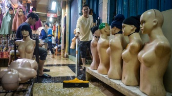 Pedagang membersihkan genangan air di Pasar Cipulir, Jakarta, Kamis (22/1/2026). [ANTARA FOTO/Putra M. Akbar/agr]