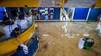 Buruh angkut melihat kondisi genangan air di Pasar Cipulir, Jakarta, Kamis (22/1/2026). [ANTARA FOTO/Putra M. Akbar/agr]
