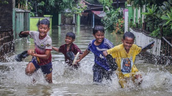 Empat anak berlari di permukiman yang terendam banjir, Desa Karangligar, Telukjambe, Karawang, Jawa Barat, Kamis (22/1/2026). [ANTARA FOTO/Darryl Ramadhan/app/tom]