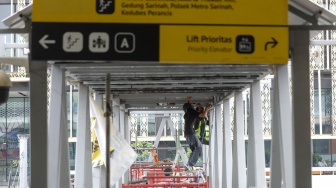 Pekerja menyelesaikan pembangunan Jembatan Penyeberangan Orang (JPO) Sarinah, Jakarta Pusat, Senin (26/1/2026). [Suara.com/Alfian Winanto]