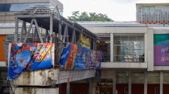 Pekerja menyelesaikan pembangunan Jembatan Penyeberangan Orang (JPO) Sarinah, Jakarta Pusat, Senin (26/1/2026). [Suara.com/Alfian Winanto]