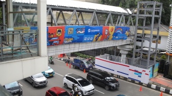 Pekerja menyelesaikan pembangunan Jembatan Penyeberangan Orang (JPO) Sarinah, Jakarta Pusat, Senin (26/1/2026). [Suara.com/Alfian Winanto]