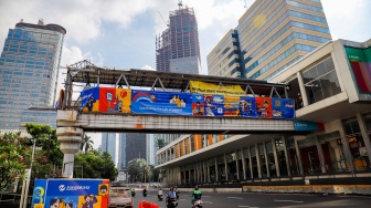 Pekerja menyelesaikan pembangunan Jembatan Penyeberangan Orang (JPO) Sarinah, Jakarta Pusat, Senin (26/1/2026). [Suara.com/Alfian Winanto]