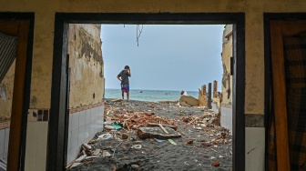 Warga berada dekat rumah yang rusak diterjang gelombang tinggi di pesisir kampung nelayan, Lingkungan Bugis, Ampenan, Mataram, NTB, Senin (26/1/2026). [ANTARA FOTO/Ahmad Subaidi/nz]