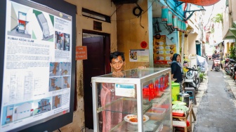 Warga berdiri di depan rumahnya yang sudah direnovasi di perkampungan padat penduduk, kawasan Menteng Tenggulun, Jakarta, Rabu (28/1/2026). [Suara.com/Alfian Winanto]
