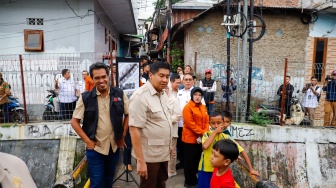 Menteri Perumahan dan Kawasan Permukiman (PKP) Maruar Sirait (tengah) menyapa warga perkampungan padat penduduk di kawasan Menteng Tenggulun, Jakarta, Rabu (28/1/2026). [Suara.com/Alfian Winanto]
