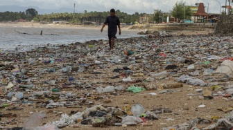 Seorang warga berjalan diatas tumpukan sampah di Pesisir Taman Wisata Laut Teluk Kupang, Kota Kupang, Nusa Tenggara Timur, Kamis (29/1/2026).  [ANTARA FOTO/Mega Tokan/bar]