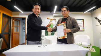 Wakil Ketua Umum AMSI Suwarjono (kiri) dan CEO Deep Intelligence Research Adi Prasetya (kanan) menekan Memorandum of Understanding kerja sama diseminasi riset di kantor Redaksi Suara.com, Jakarta, Jumat (30/1/2026). [Suara.com/Alfian Winanto]