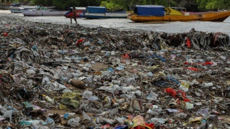 Seorang warga menarik tali perahu melewati tumpukan sampah di Pesisir Taman Wisata Laut Teluk Kupang, Kota Kupang, Nusa Tenggara Timur, Kamis (29/1/2026).  [ANTARA FOTO/Mega Tokan/bar]
