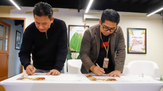 Wakil Ketua Umum AMSI Suwarjono (kiri) dan CEO Deep Intelligence Research Adi Prasetya (kanan) menekan Memorandum of Understanding kerja sama diseminasi riset di kantor Redaksi Suara.com, Jakarta, Jumat (30/1/2026). [Suara.com/Alfian Winanto]