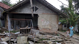 Warga melintas di samping rumah yang rusak akibat pergerakan tanah di Kampung Nanggerang, Desa Pabuaran, Sukamakmur, Kabupaten Bogor, Jawa Barat, Senin (2/2/2026). [ANTARA FOTO/Yulius Satria Wijaya/wsj]