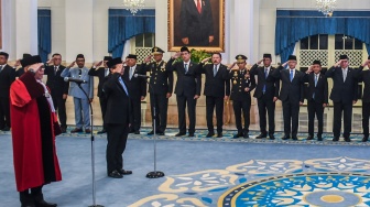 Hakim MK Adies Kadir (kiri) dan Wamenkeu Juda Agung (kedua kiri) mengikuti pembacaan sumpah jabatan pada pelantikan Hakim Mahkamah Konstitusi (MK) dan Wakil Menteri Keuangan di Istana Negara, Jakarta, Kamis (5/2/2026). [ANTARA FOTO/Galih Pradipta/foc]