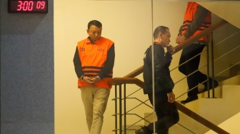 Ketua Pengadilan Negeri (PN) Depok I Wayan Eka Mariarta (tengah) dibawa ke mobil tahanan usai ditetapkan jadi tersangka di Gedung Merah Putih KPK, Jakarta, Jumat (6/2/2026). [Suara.com/Alfian Winanto]