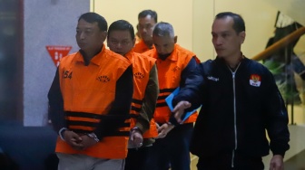 Ketua Pengadilan Negeri (PN) Depok I Wayan Eka Mariarta (kiri) dan Wakil Ketua PN Depok Bambang Setyawan (kedua kiri) dan tersangka lainnya dibawa ke mobil tahanan usai ditetapkan jadi tersangka di Gedung Merah Putih KPK, Jakarta, Sabtu (7/2/2026). [Suara.com/Alfian Winanto]