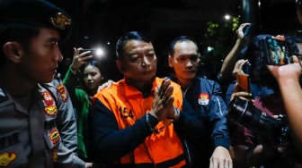 Ketua Pengadilan Negeri (PN) Depok I Wayan Eka Mariarta (tengah) dibawa ke mobil tahanan usai ditetapkan jadi tersangka di Gedung Merah Putih KPK, Jakarta, Sabtu (7/2/2026). [Suara.com/Alfian Winanto]