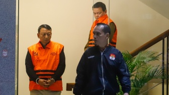 Ketua Pengadilan Negeri (PN) Depok I Wayan Eka Mariarta (kiri) dan Wakil Ketua PN Depok Bambang Setyawan (belakang) dibawa ke mobil tahanan usai ditetapkan jadi tersangka di Gedung Merah Putih KPK, Jakarta, Sabtu (7/2/2026). [Suara.com/Alfian Winanto]