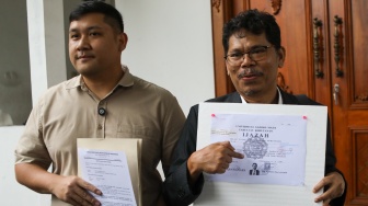 Pengamat Kebijakan Publik Bonatua Silalahi (kanan) menunjukan salinan asli ijazah Presiden ke-7 Joko Widodo di depan kantor KPU RI, Jakarta, Senin (9/2/2026). [Suara.com/Alfian Winanto]

