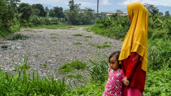 Warga mengamati sampah yang menumpuk di Sungai Citarum Lama, di Margaasih, Kabupaten Bandung, Jawa Barat, Kamis (12/2/2026). 
[ANTARA FOTO/Raisan Al Farisi/bar]
