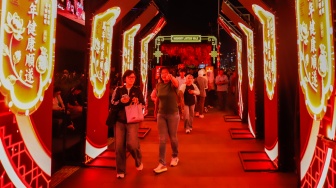 Warga melihat instalasi pencahayaan dalam Jakarta Light Festival edisi Imlek di kawasan Bundaran HI, Jakarta, Jumat (13/2/2026). [Suara.com/Alfian Winanto]
