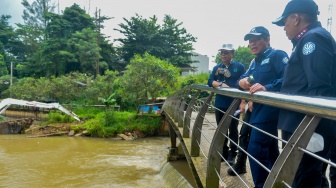 Menteri Lingkungan Hidup Hanif Faisol Nurofiq (tengah) bersama Deputi Bidang Penegakan Hukum KLH Irjen Pol Rizal Irawan (kanan) dan Deputi Bidang Pengendalian Pencemaran dan Kerusakan Lingkungan KLH Rasio Ridho Sani (kiri) meninjau aliran Sungai Jaletreng di Kota Tangerang Selatan, Banten, Jumat (13/2/2026). [ANTARA FOTO/Putra M. Akbar/wsj]