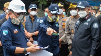 Menteri Lingkungan Hidup Hanif Faisol Nurofiq (tengah) bersama Deputi Bidang Penegakan Hukum KLH Irjen Pol Rizal Irawan (kanan) dan Deputi Bidang Pengendalian Pencemaran dan Kerusakan Lingkungan KLH Rasio Ridho Sani (kiri) meninjau aliran Sungai Jaletreng di Kota Tangerang Selatan, Banten, Jumat (13/2/2026). [ANTARA FOTO/Putra M. Akbar/wsj]