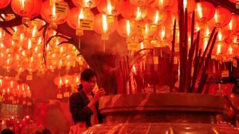 Umat Konghucu beribadah malam perayaan Tahun Baru Imlek 2577 Kongzili di Wihara Boen San Bio, Kota Tangerang, Banten, Senin (16/2/2026).  [Suara.com/Alfian Winanto]