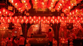 Umat Konghucu beribadah malam perayaan Tahun Baru Imlek 2577 Kongzili di Wihara Boen San Bio, Kota Tangerang, Banten, Senin (16/2/2026).  [Suara.com/Alfian Winanto]