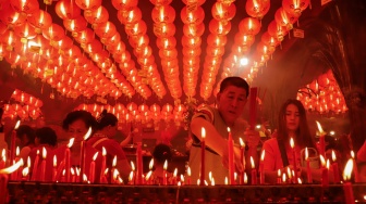 Umat Konghucu beribadah malam perayaan Tahun Baru Imlek 2577 Kongzili di Wihara Boen San Bio, Kota Tangerang, Banten, Senin (16/2/2026).  [Suara.com/Alfian Winanto]