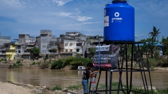Seorang anak terdampak bencana alam mengambil air bersih di Desa Sukajadi, Aceh Tamiang, Aceh, Jumat (20/2/2026). [ANTARA FOTO/Aprillio Akbar/bar]
