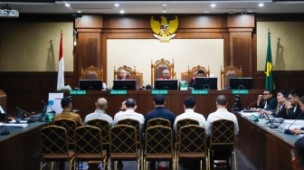 Terdakwa kasus dugaan korupsi tata kelola minyak mentah dan produk kilang Muhammad Kerry Adrianto Riza (tengah) saat menjalani sidang di Pengadilan Tipikor, Jakarta, Kamis (19/2/2026). [Suara.com/Alfian Winanto]