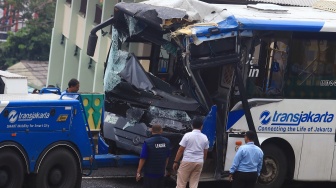 Sejumlah petugas berada di dekat bus TransJakarta yang mengalami kecelakaan tabrakan antar sesama bus TransJakarta di jalur layang atau jalur langit Koridor 13, Cipulir, Jakarta, Senin (23/2/2026). [ANTARA FOTO/Muhammad Iqbal/YU]
