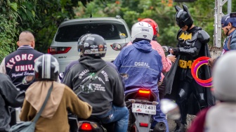 Anggota Komunitas Badut Cimahi mengenakan kostum superhero saat membagikan takjil kepada pengendara di Kota Cimahi, Jawa Barat, Senin (23/2/2026). [ANTARA FOTO/Abdan Syakura/rwa]
