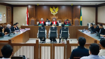 Terdakwa kasus dugaan korupsi tata kelola minyak mentah dan produk kilang Muhammad Kerry Adrianto (kanan) saat datang untuk menjalani sidang di Pengadilan Tipikor, Jakarta, Senin (23/2/2026). [Suara.com/Alfian Winanto]