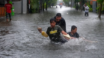 Sejumlah anak bermain di tengah banjir di Denpasar, Bali, Selasa (24/2/2026). [ANTARA FOTO/Nyoman Hendra Wibowo/nym]