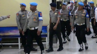 Anggota Propam Polri membawa tersangka selaku Bripda Mesias Viktor Siahaya (ketiga kiri) menuju ruang Sidang Komisi Kode Etik Profesi (KKEP) Polri di Mapolda Maluku, Ambon, Maluku, Selasa (24/2/2026). [ANTARA FOTO/Alfian Sanusi/sgd]