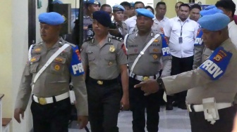 Anggota Propam Polri membawa tersangka selaku Bripda Mesias Viktor Siahaya (kedua kiri) menuju ruang Sidang Komisi Kode Etik Profesi (KKEP) Polri di Mapolda Maluku, Ambon, Maluku, Selasa (24/2/2026). [ANTARA FOTO/Alfian Sanusi/sgd]