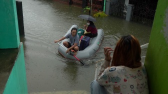 Seorang relawan mengevakuasi warga yang terdampak banjir di Kecamatan Manggala, Makassar, Sulawesi Selatan, Rabu (25/2/2026). [ANTARA FOTO/Hasrul Said/tom]
