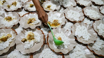 Relawan menuangkan lauk ke makanan sahur yang akan dibagikan secara gratis kepada warga di Palu, Sulawesi Tengah, Jumat (27/2/2026). [ANTARA FOTO/Basri Marzuki/wpa]