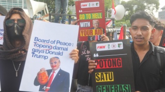 Sejumlah massa membentangkan poster saat mengikuti aksi solidaritas untuk Iran di depan Kedubes Amerika di Jakarta, Selasa (3/3/2026). [Suara.com/Alfian Winanto]