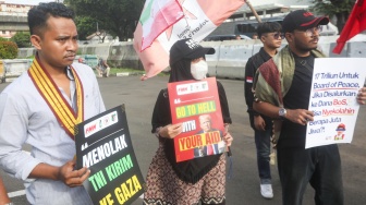 Sejumlah massa membentangkan poster saat mengikuti aksi solidaritas untuk Iran di depan Kedubes Amerika di Jakarta, Selasa (3/3/2026). [Suara.com/Alfian Winanto]