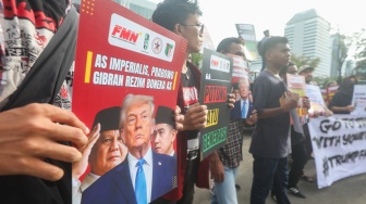 Sejumlah massa membentangkan poster saat mengikuti aksi solidaritas untuk Iran di depan Kedubes Amerika di Jakarta, Selasa (3/3/2026). [Suara.com/Alfian Winanto]