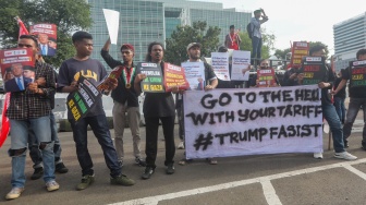 Sejumlah massa membentangkan poster saat mengikuti aksi solidaritas untuk Iran di depan Kedubes Amerika di Jakarta, Selasa (3/3/2026). [Suara.com/Alfian Winanto]